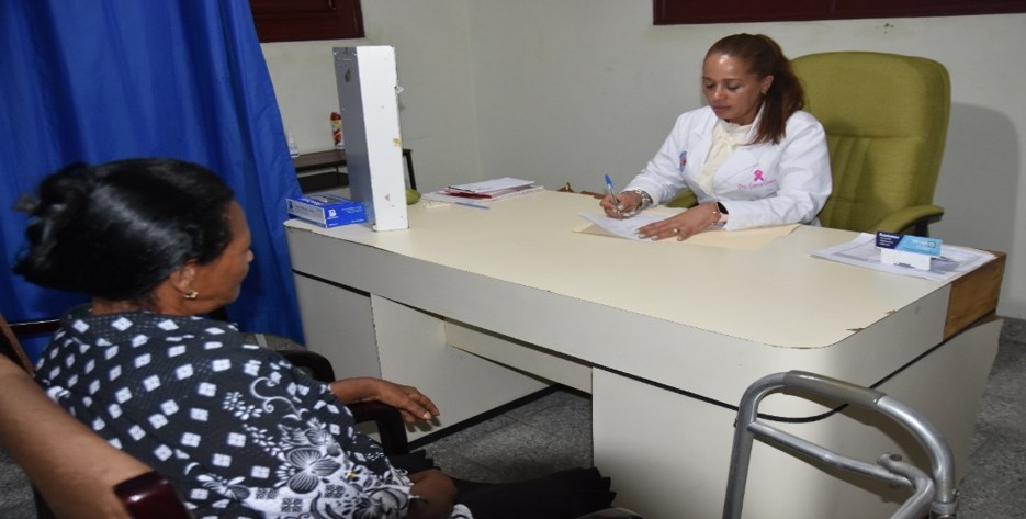 Doctora atendiendo a paciente con lazo rosa